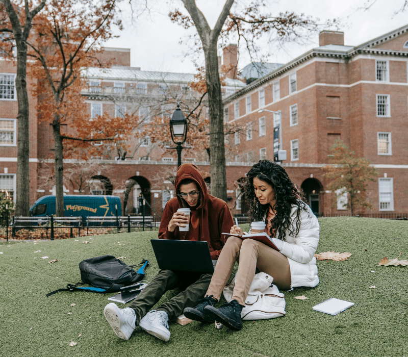Two college students sitting outside on campus